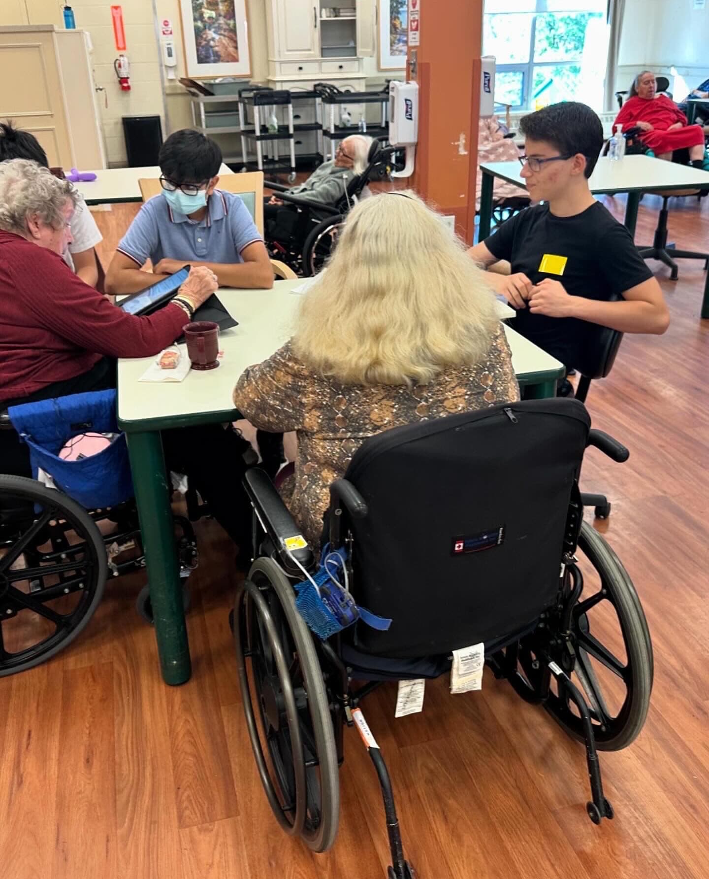 A TechWiseTutors volunteer helping community members with tablets