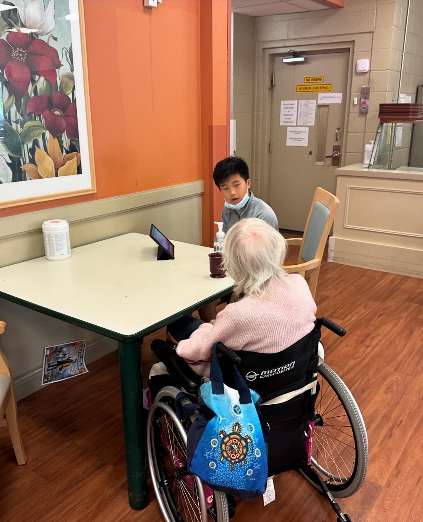 A volunteer helping a senior with a tablet